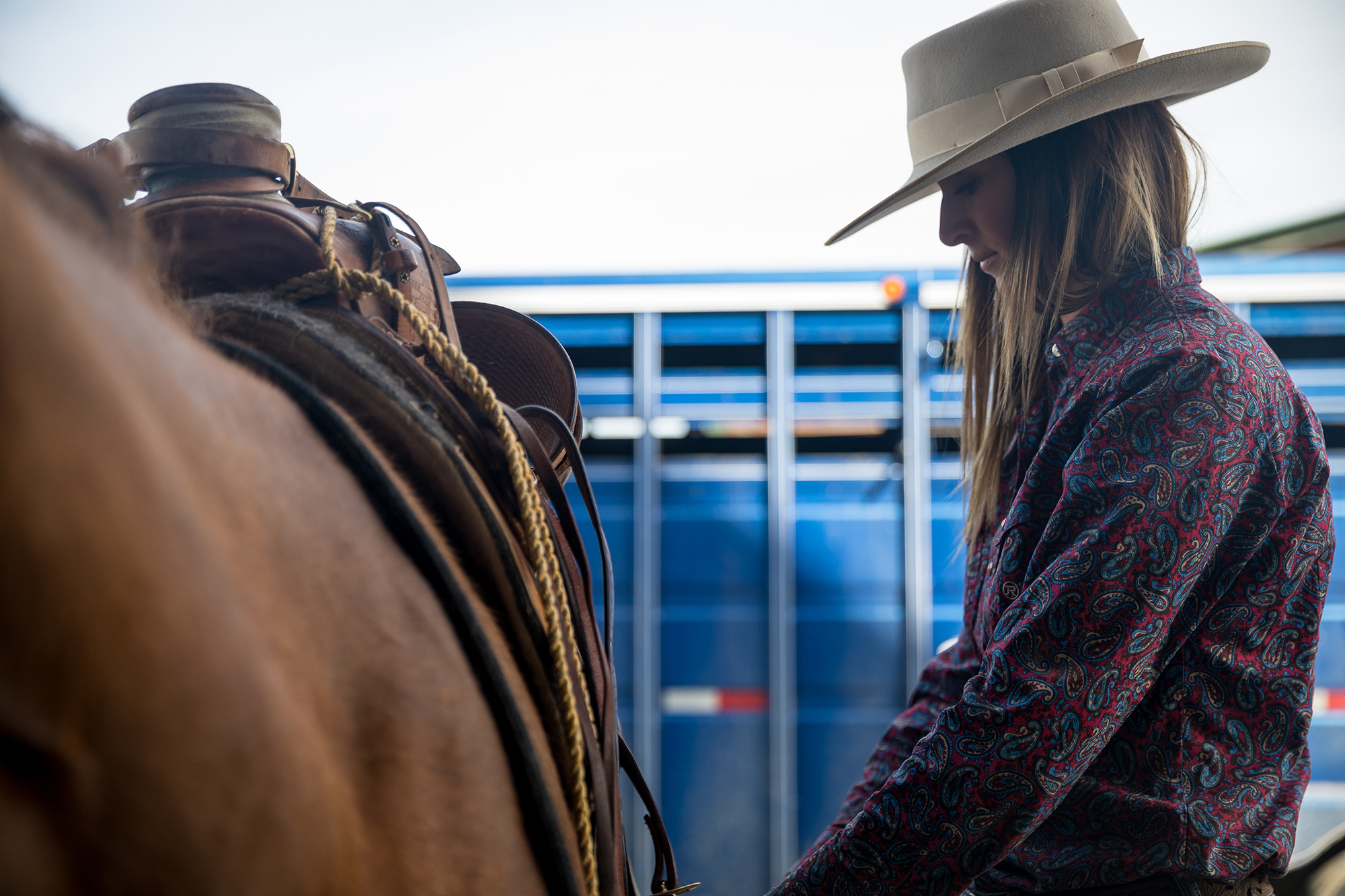 Tightening the cinch before trailering the horses to a branding.