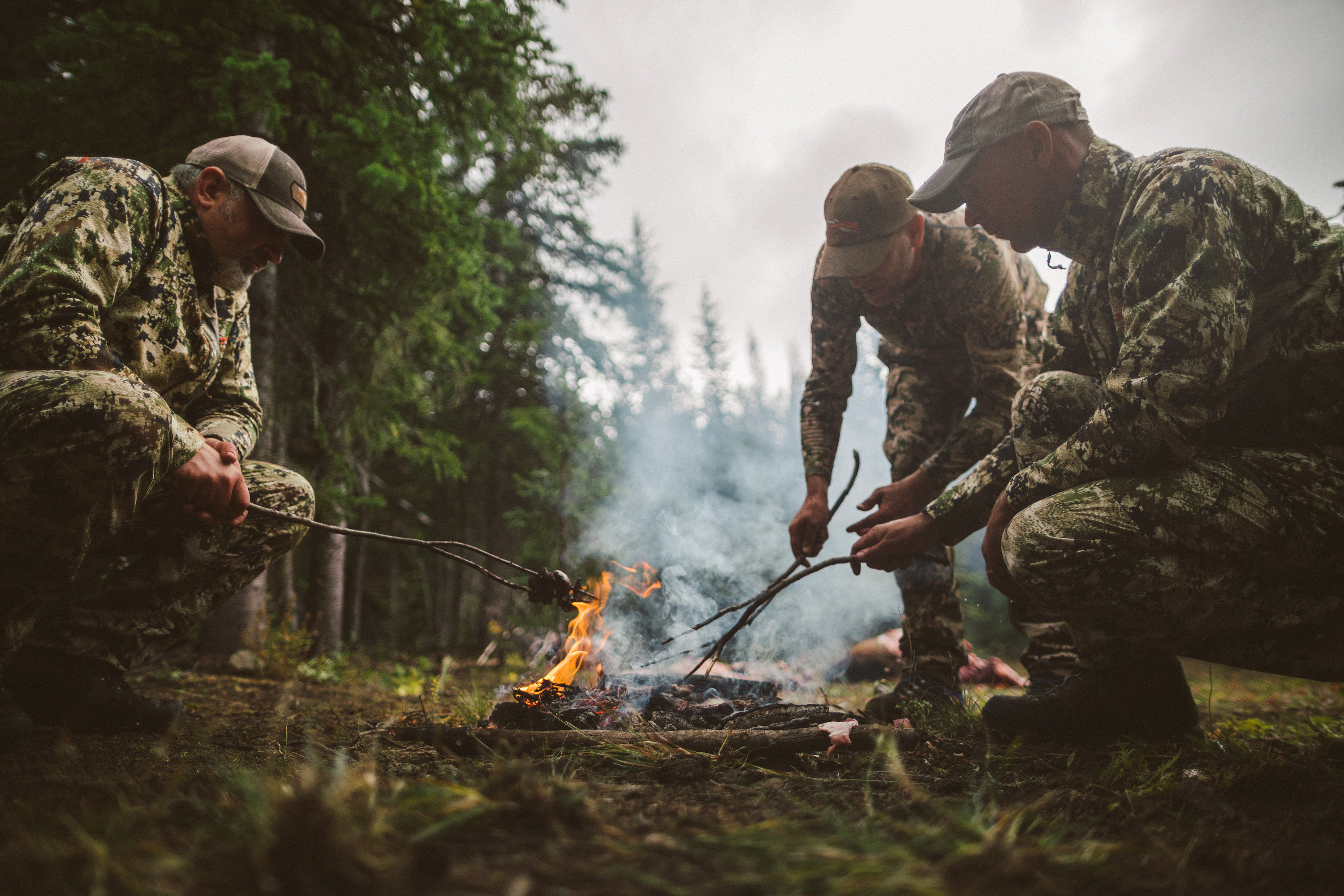 Hunters cook their harvest over an open fire.