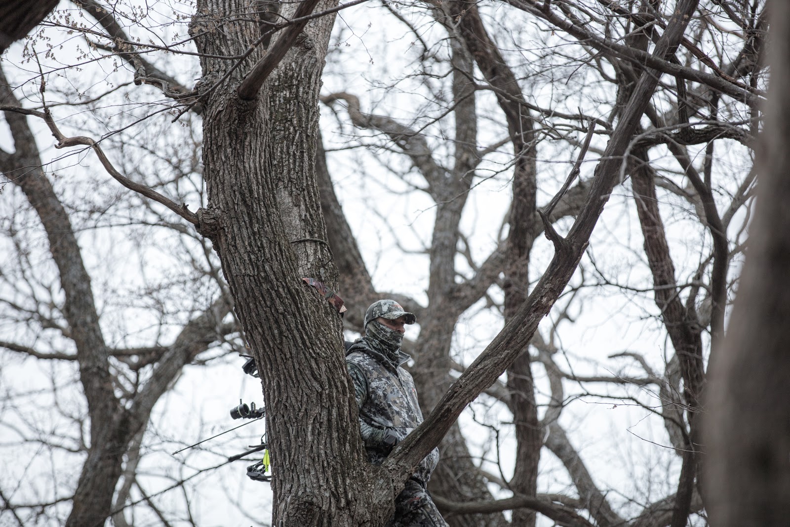 Whitetail hunter attempts to stay warm while waiting on a deer to walk by.