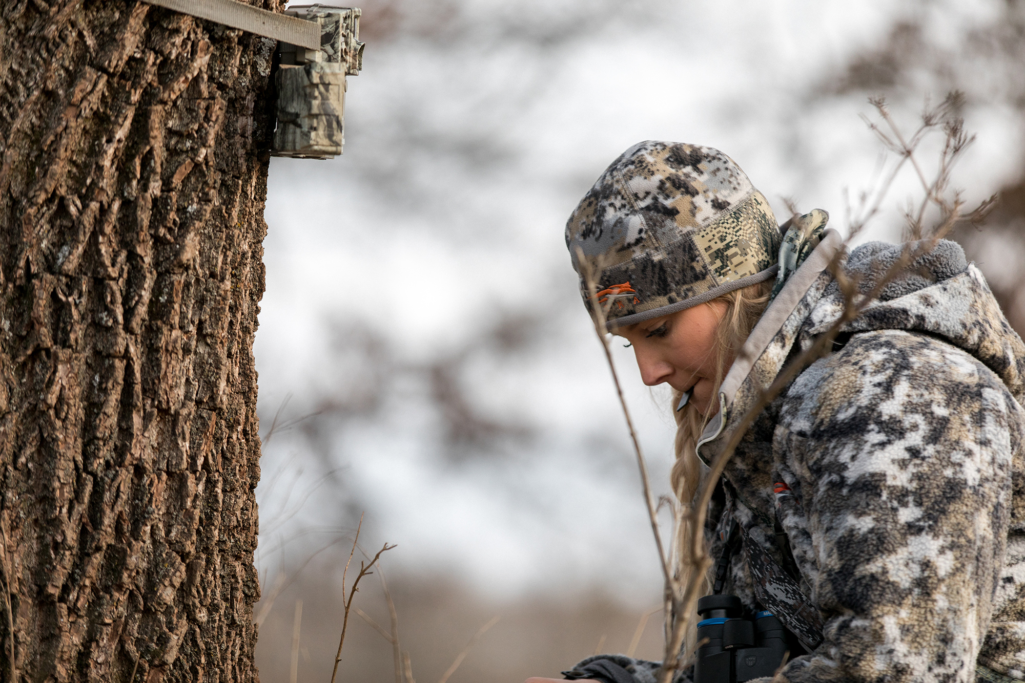 Templeton checks a trail cam for a shooter buck.