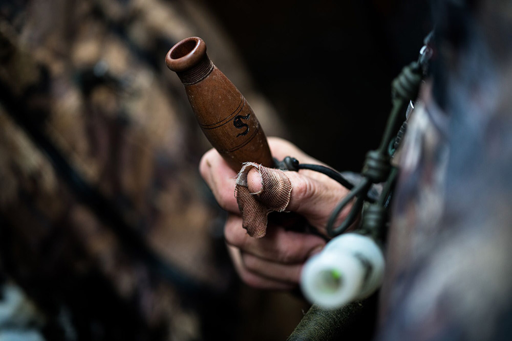 John Stephens watches ducks fly with one of his own ducks calls in hand