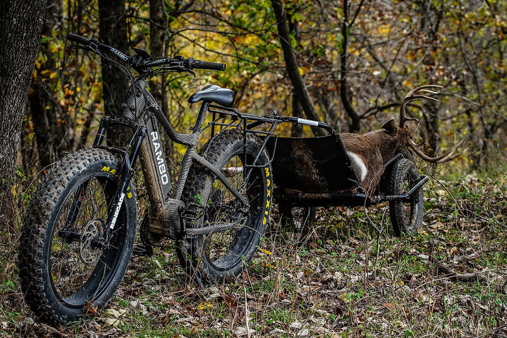 Whitetail buck getting ready to be hauled out of the woods via e-bike