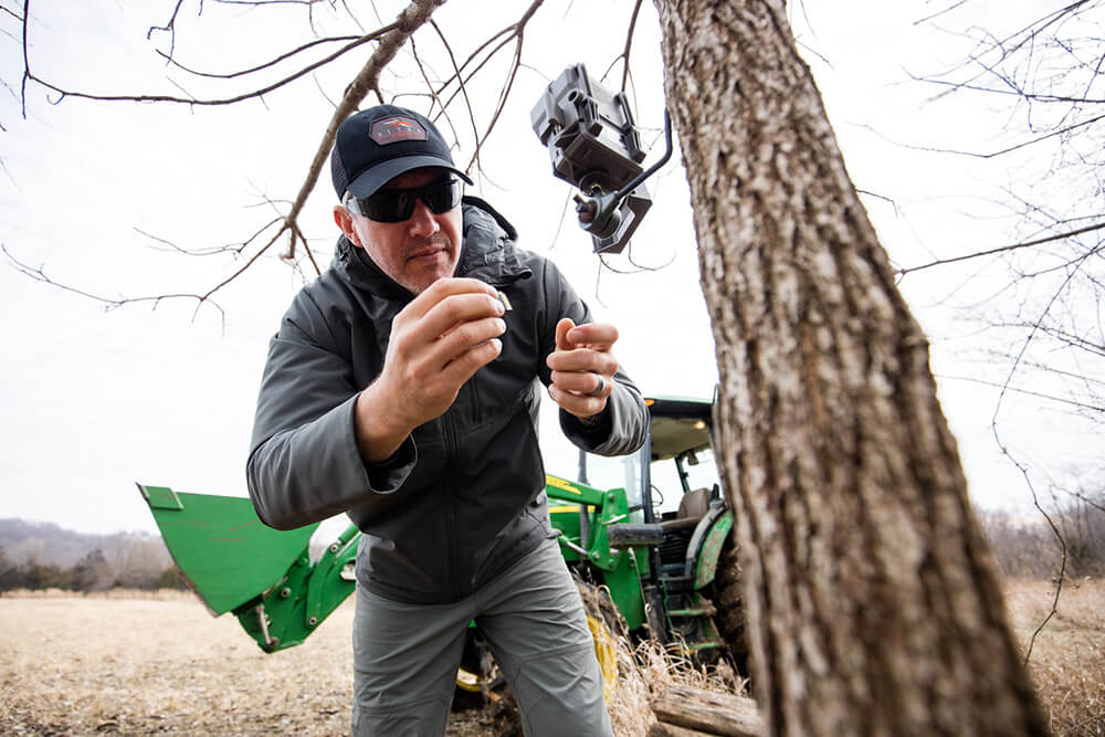 John Dudley checks a trail cam.