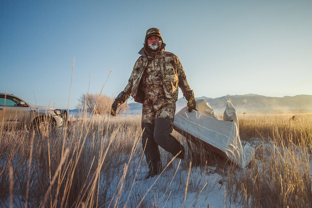 A goose hunter drags his layout blind behind him on a cold day.