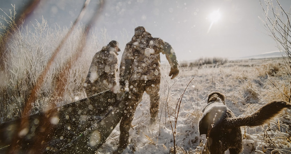Waterfowlers drag a boat behind them in late season conditions.