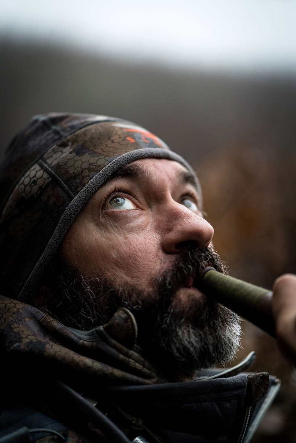 John Stephens has eyes to the sky as he blows a duck call.