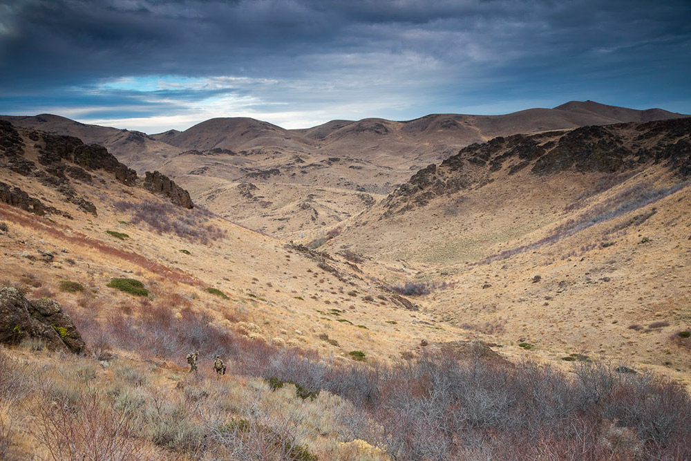 Hunters amongst mountains and hillsides.
