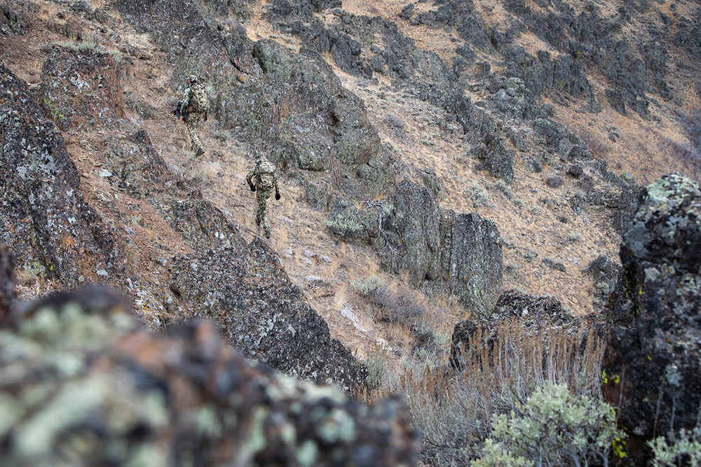 Hunters in Optifade Subalpine scale some rocky terrain.