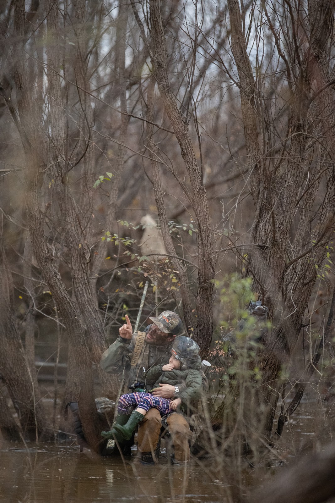 Father and daughter duck hunting in the timber.